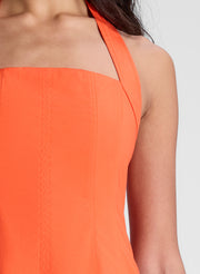 woman wearing orange halter midi dress