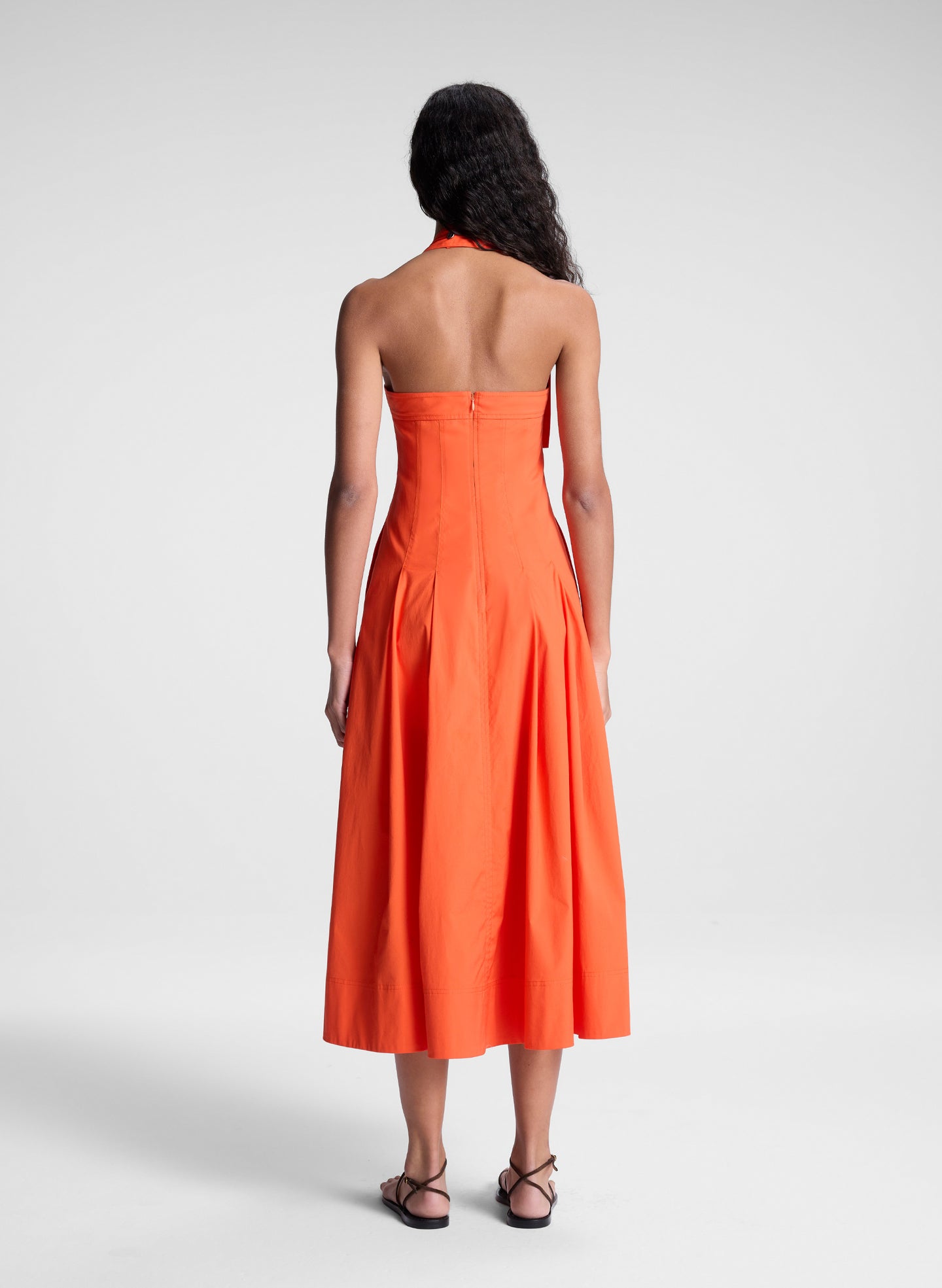 woman wearing orange halter midi dress