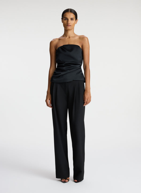 front  view of woman wearing black strapless satin top and black pants