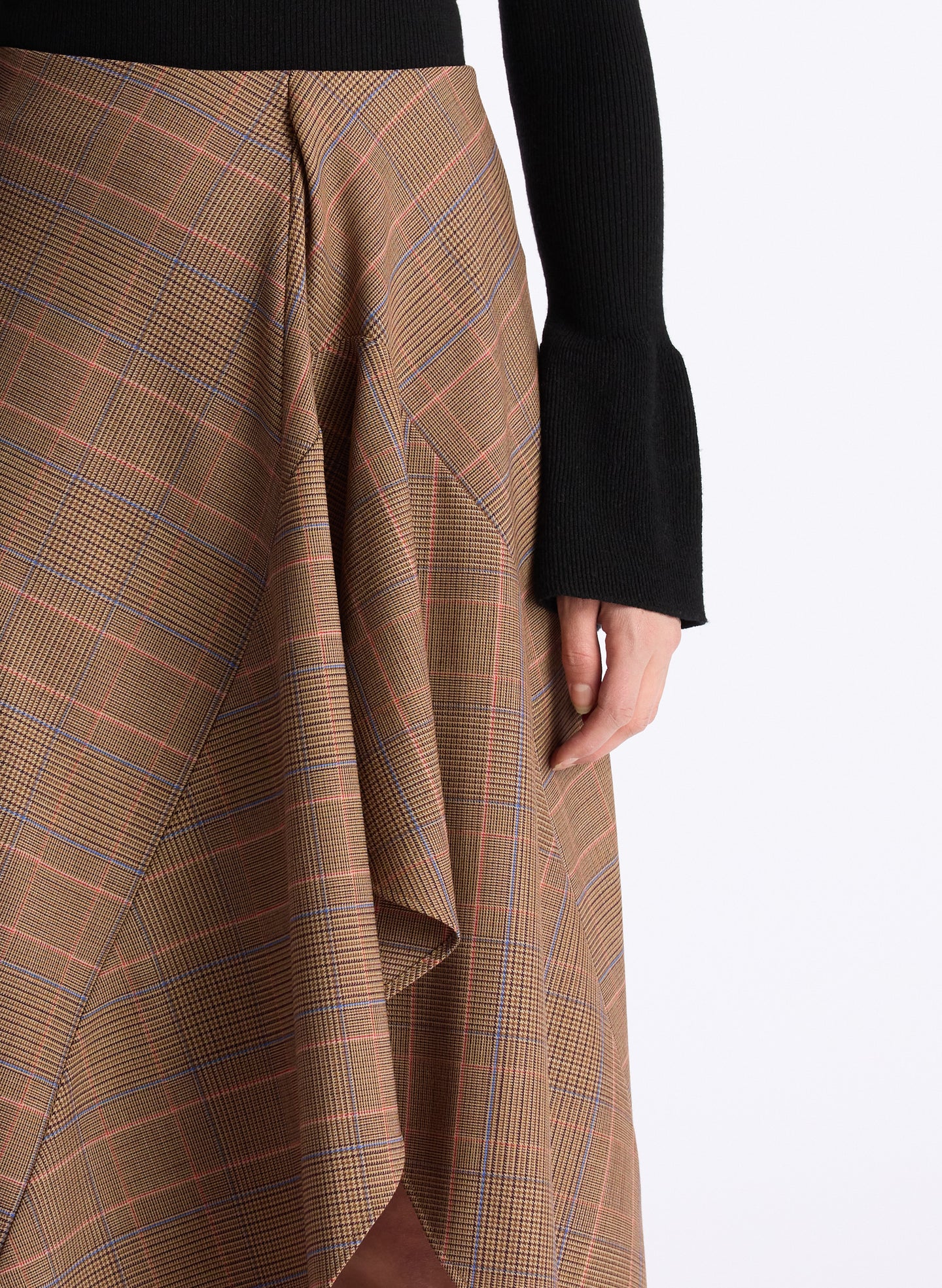 detail  view of woman wearing black sweater and brown plaid asymmetric midi skirt