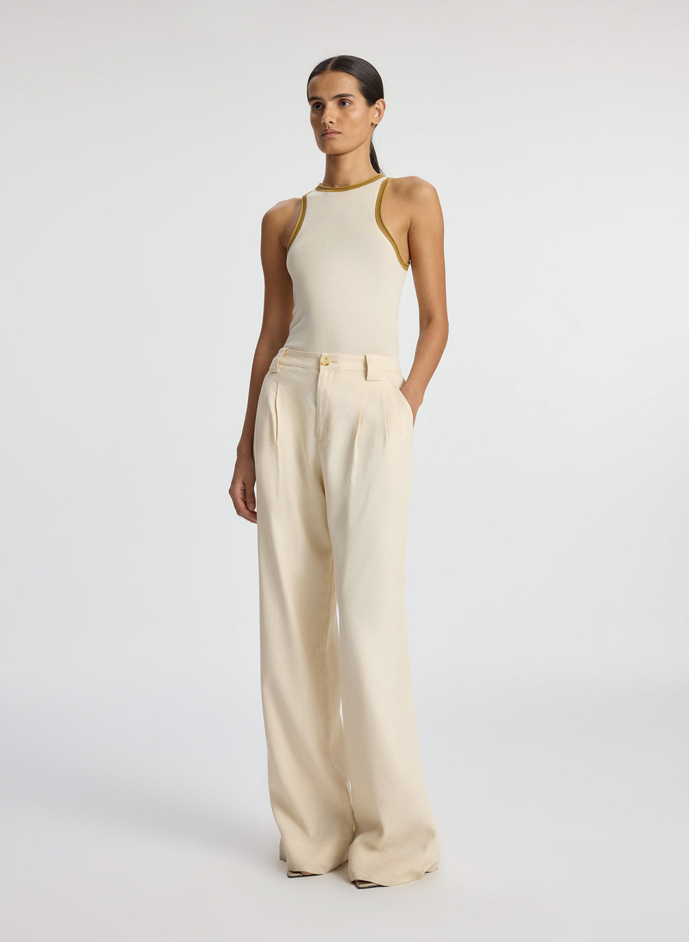 side view of woman wearing cream contrast trim tank and beige wide leg pant