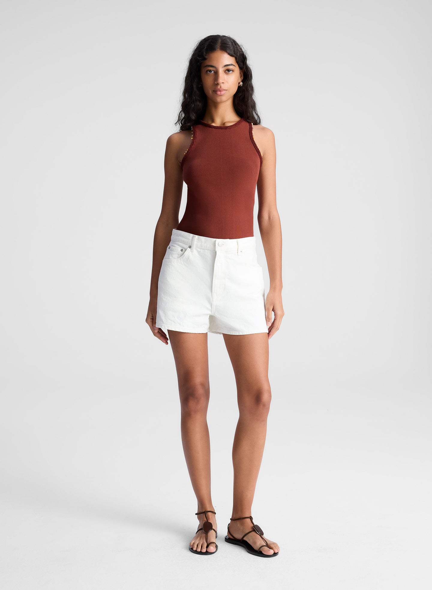 woman wearing red tank top and white denim jean shorts