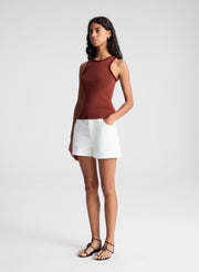 woman wearing red tank top and white denim jean shorts