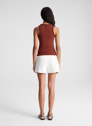 woman wearing brown embellished tank top and beige shorts