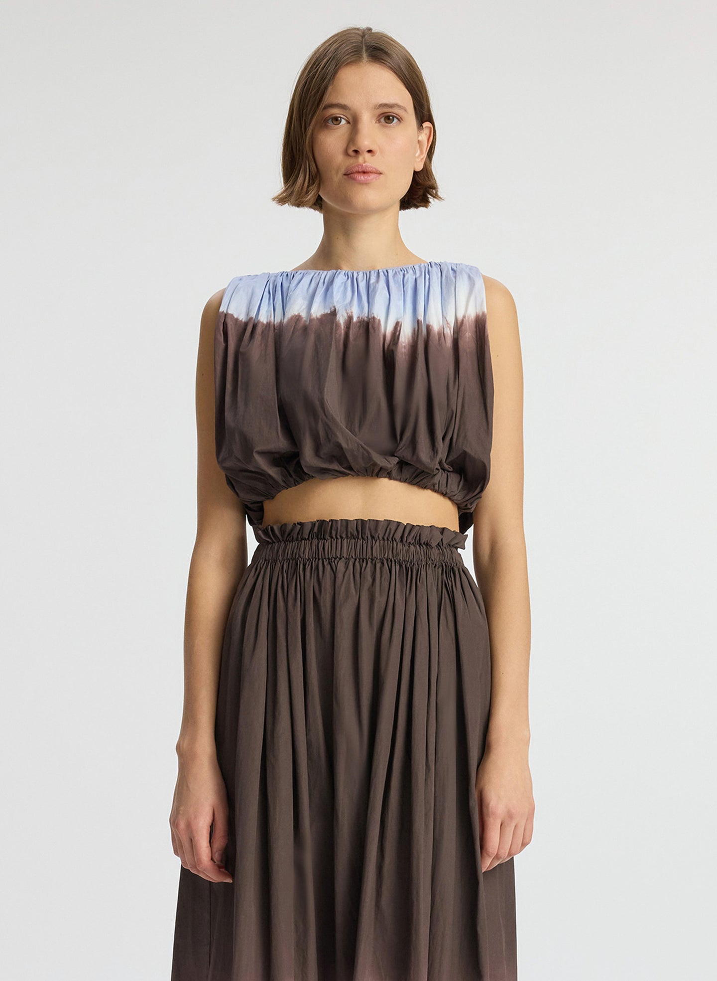 detail view of woman wearing light blue and brown dip dyed sleeveless top and matching midi skirt
