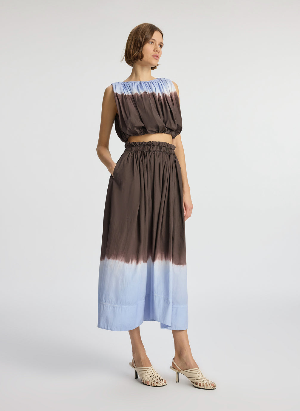 side view of woman wearing light blue and brown dip dyed sleeveless top and matching midi skirt
