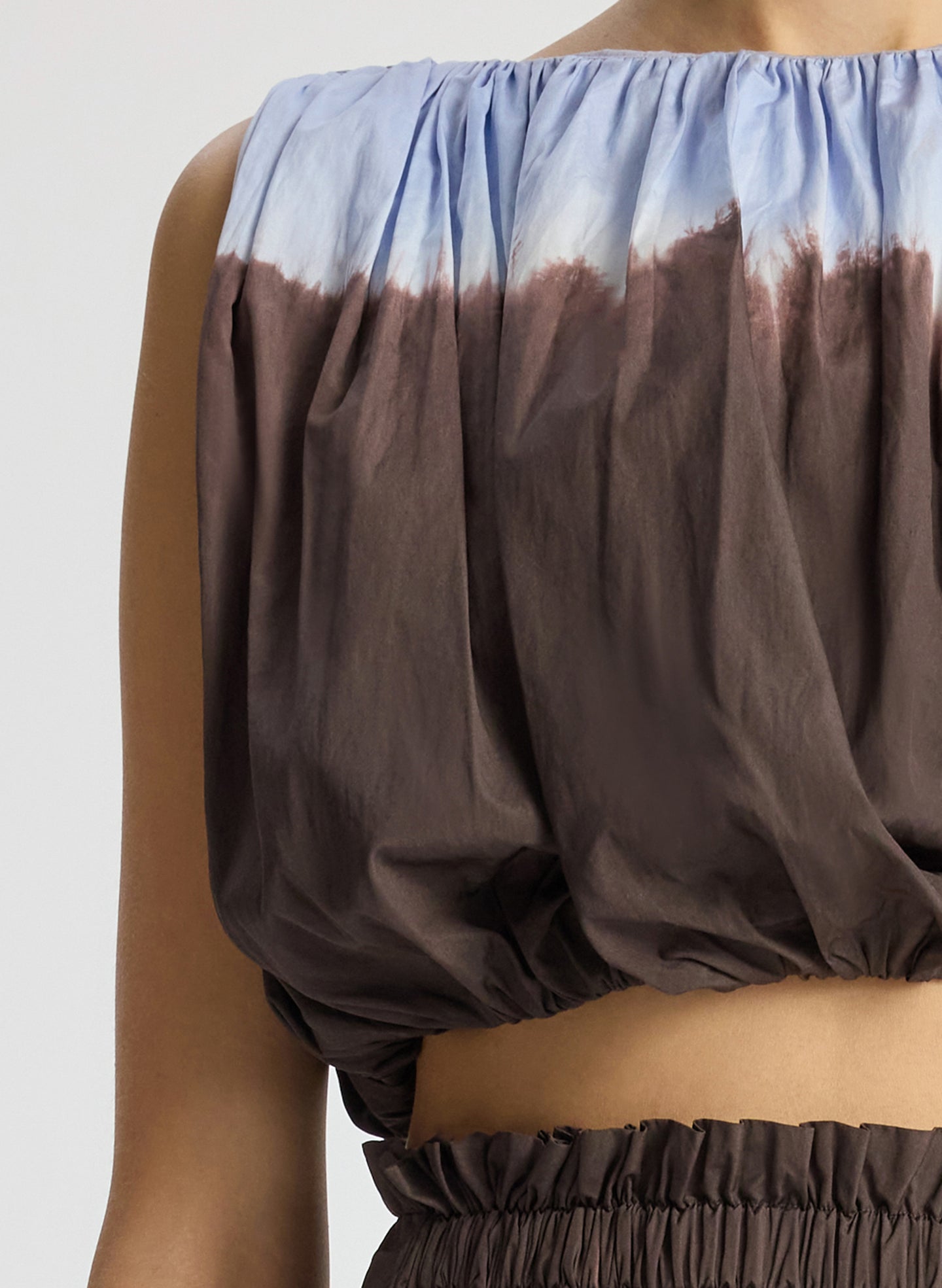 detail view of woman wearing light blue and brown dip dyed sleeveless top and matching midi skirt