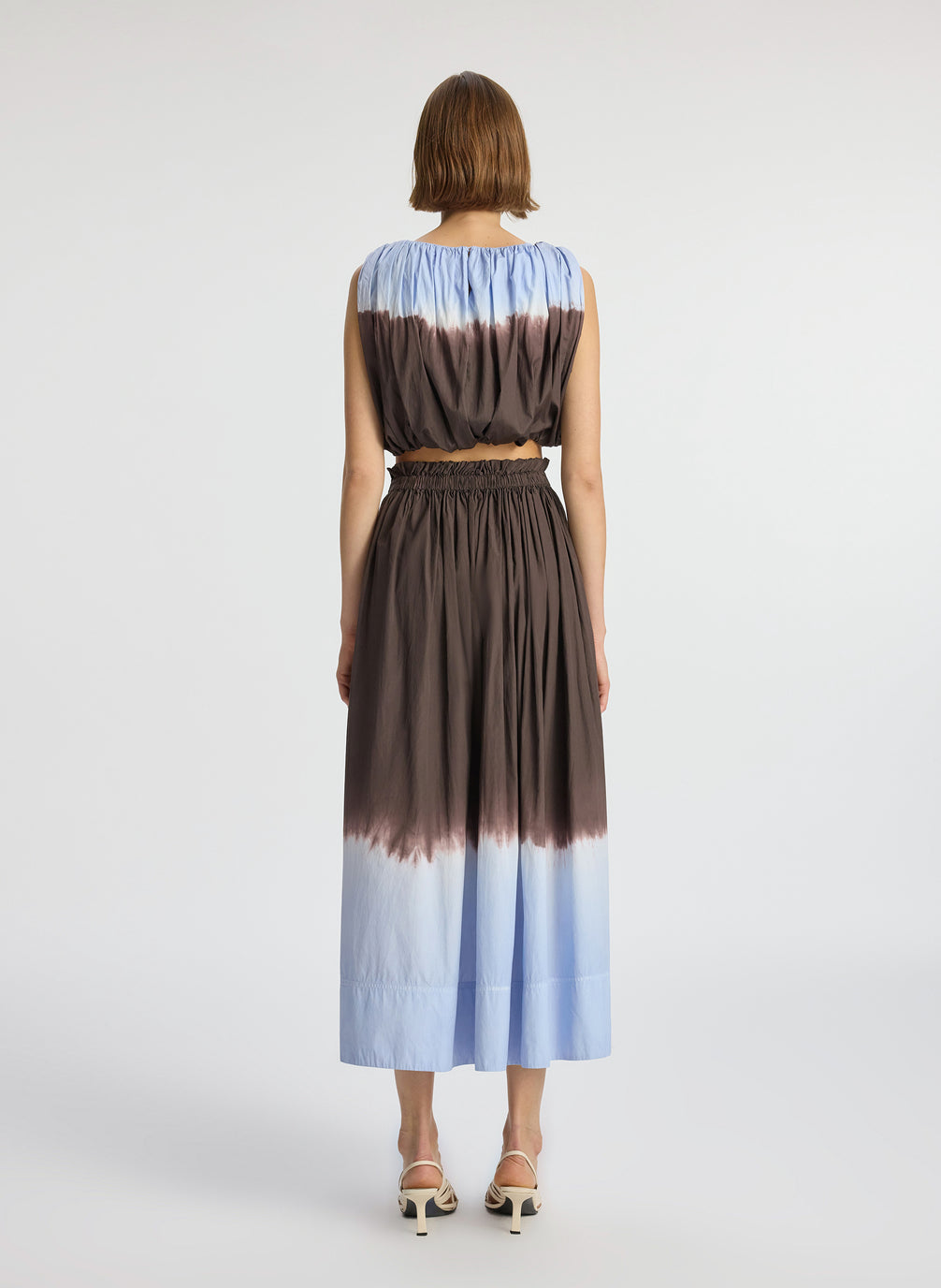 back view of woman wearing light blue and brown dip dyed sleeveless top and matching midi skirt