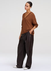 woman wearing brown sweater and brown leather pants