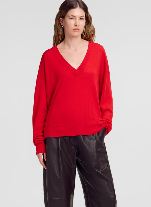 woman wearing red v neck sweater and brown leather pants