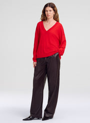 woman wearing brown leather pants with red vneck sweater