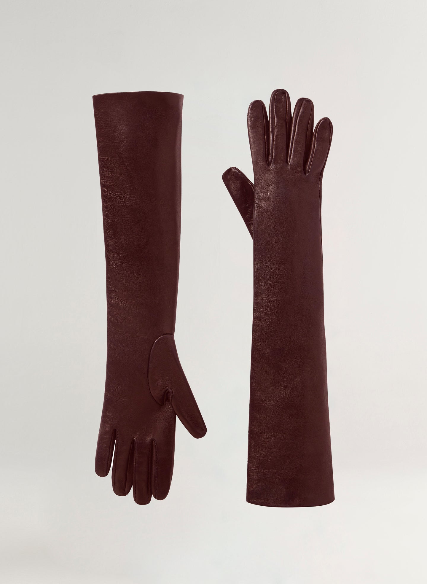 Pair of long burgundy gloves on a light gray background