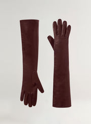 Pair of long burgundy gloves on a light gray background