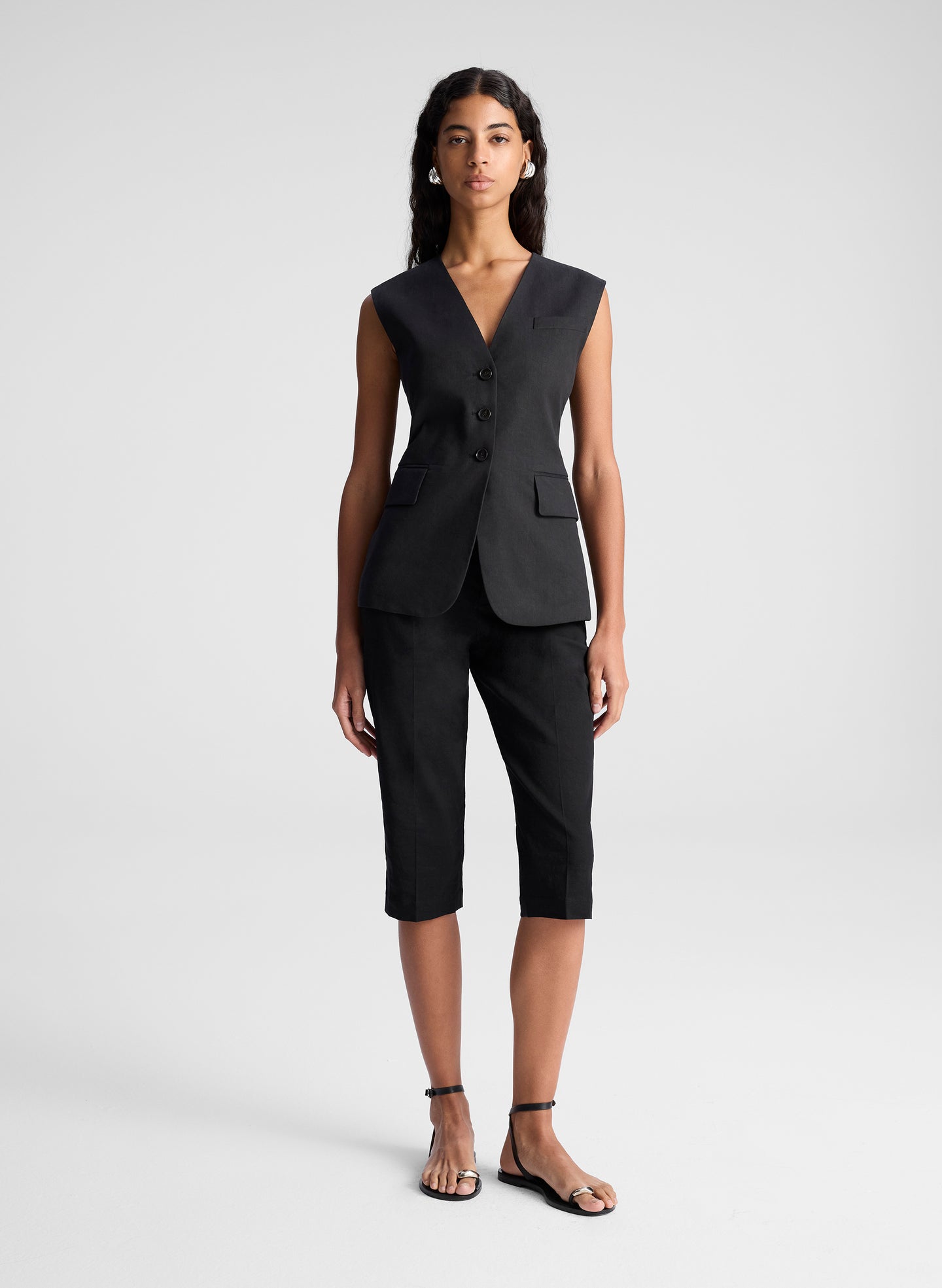 woman wearing black vest top and black capri pants