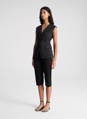 woman wearing black vest top and black capri pants