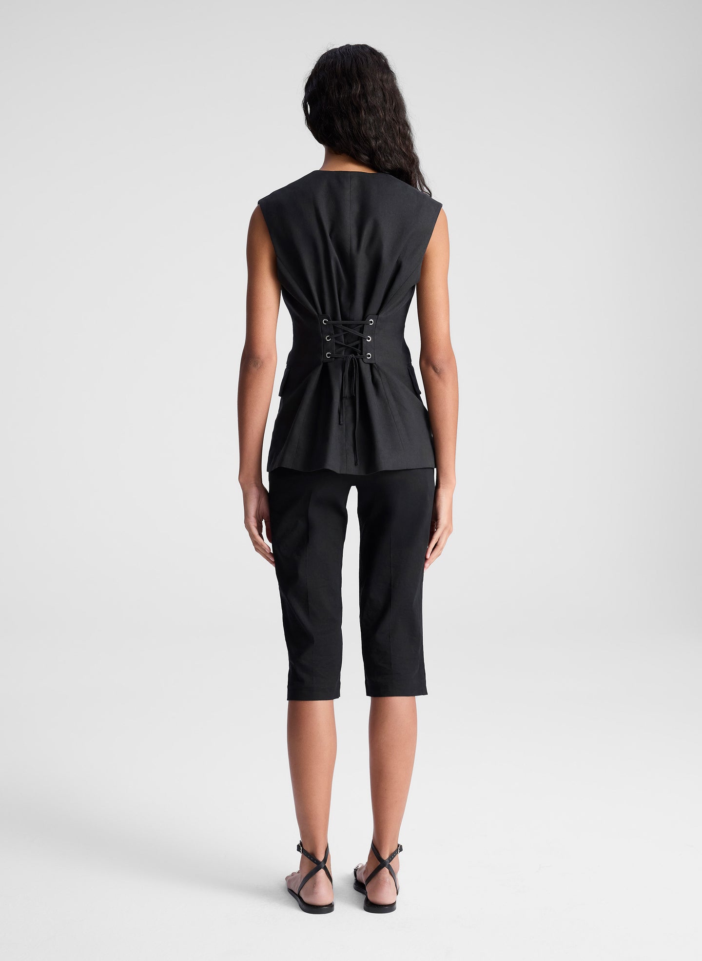 woman wearing black vest and black capri pants