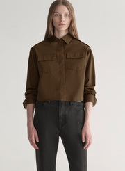 woman wearing olive green shirt and black denim jeans