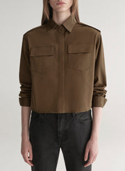 woman wearing olive green shirt and black denim jeans