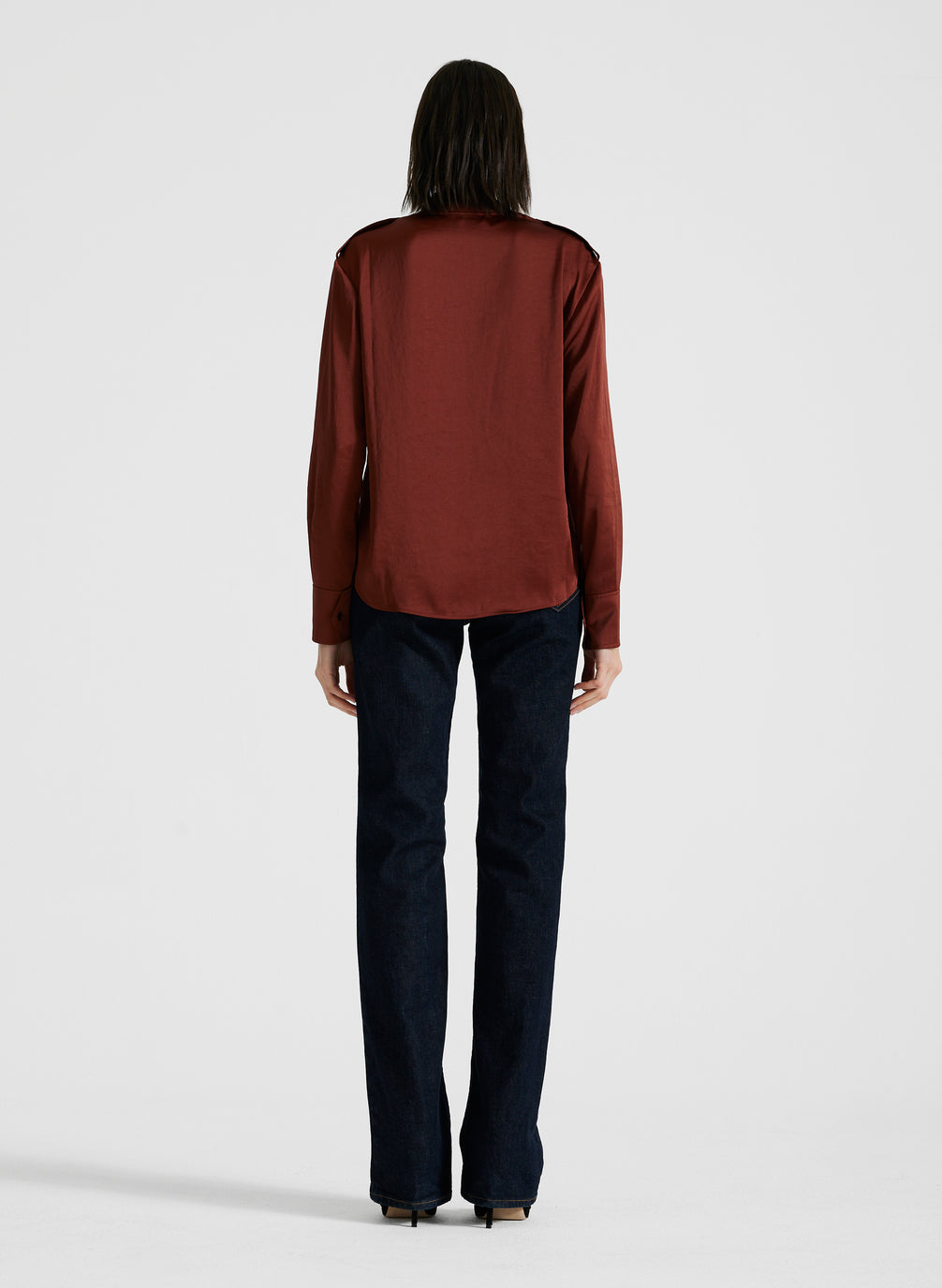 back view of woman wearing maroon satin long sleeve top and black pants