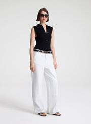 woman wearing  black sleeveless voile knit polo and white denim jeans