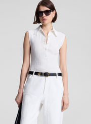 woman wearing  white sleeveless voile knit polo and white denim jeans