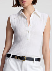 woman wearing  white sleeveless voile knit polo and white denim jeans