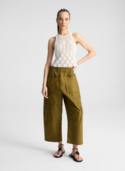 woman wearing cream knit tank and olive green wide leg pants