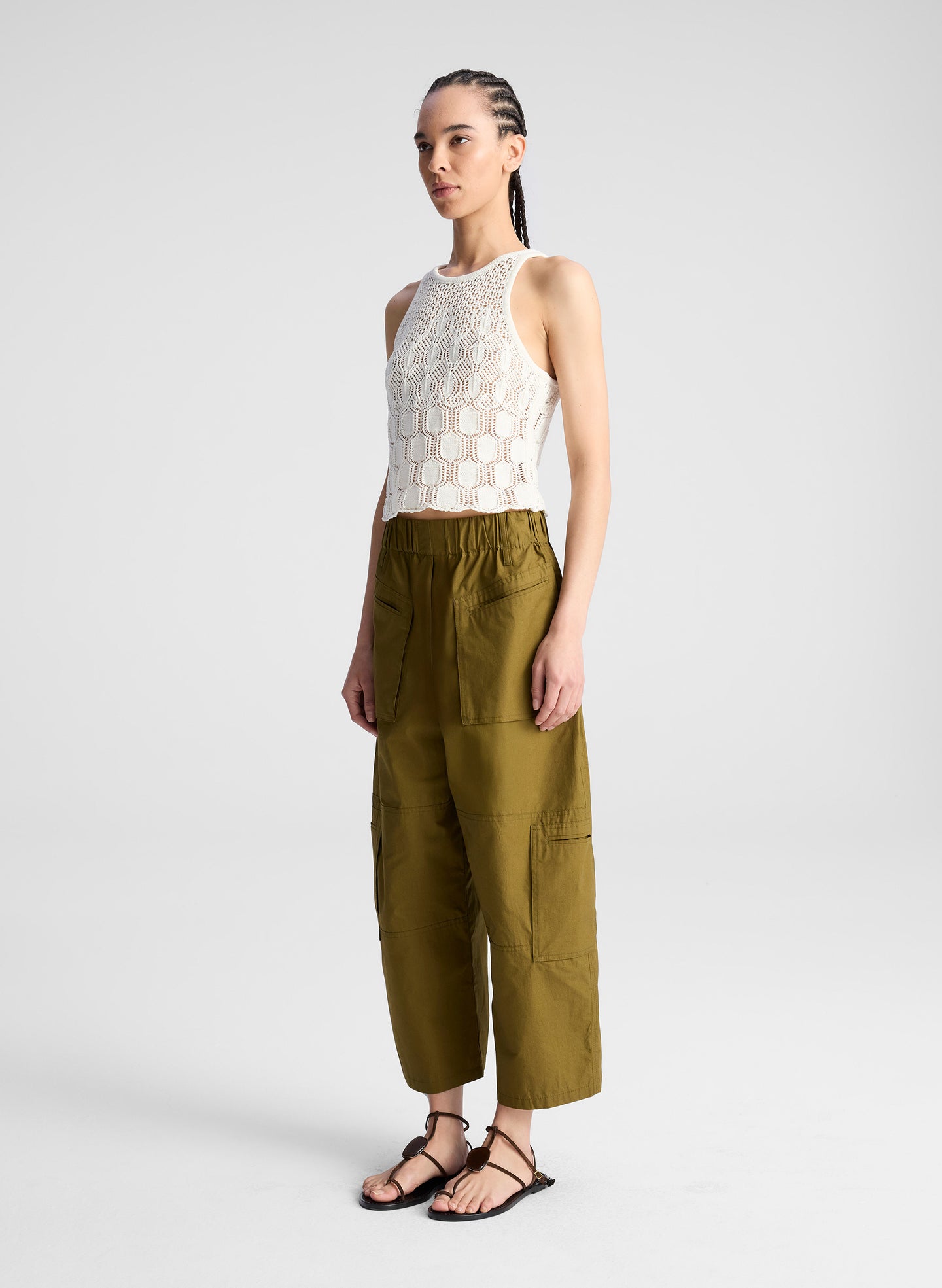 woman wearing cream knit tank and olive green wide leg pants