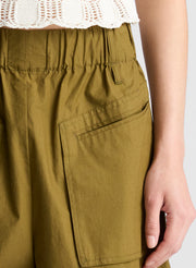 woman wearing cream knit tank and olive green wide leg pants