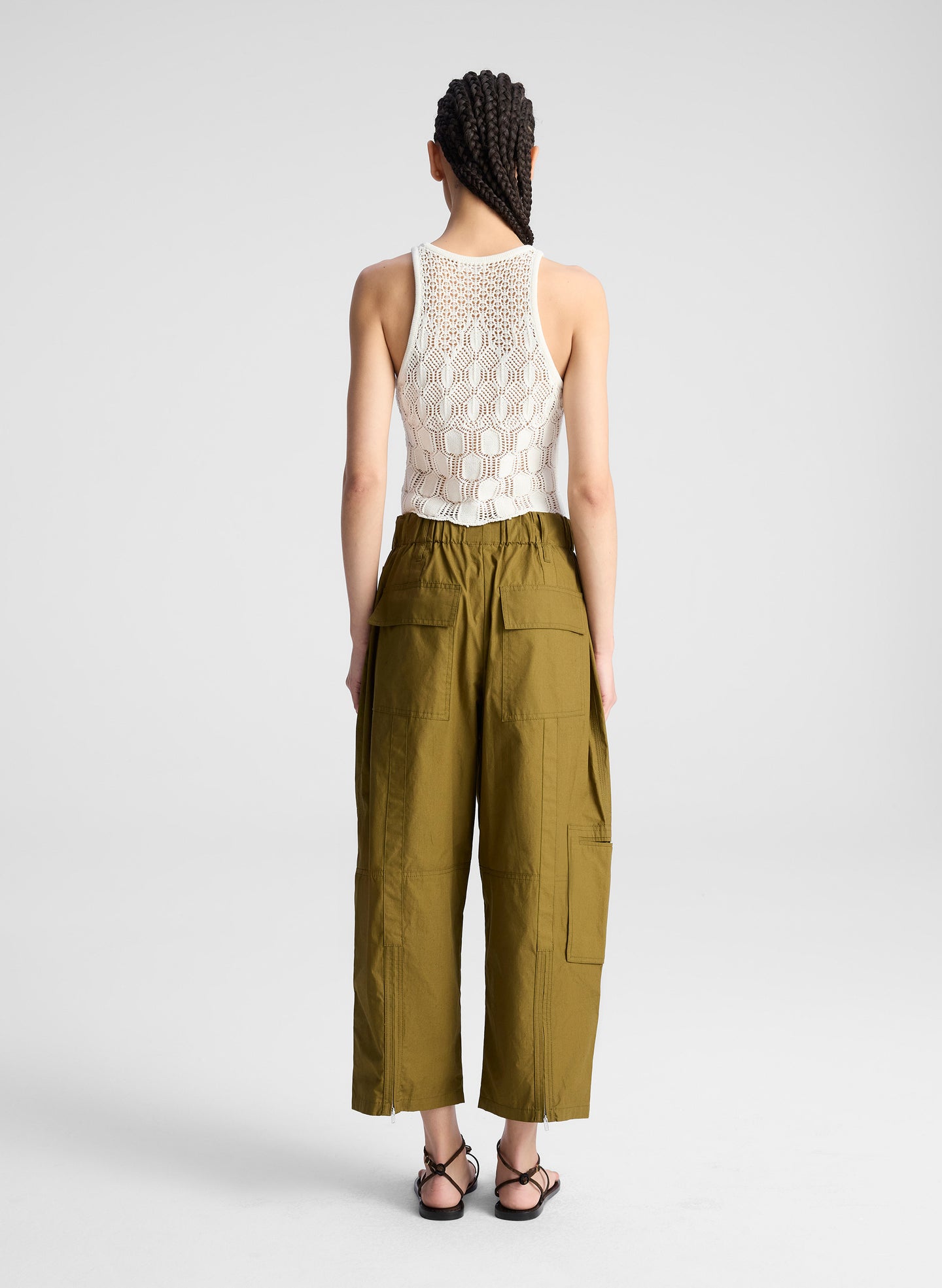 woman wearing cream knit tank and olive green wide leg pants