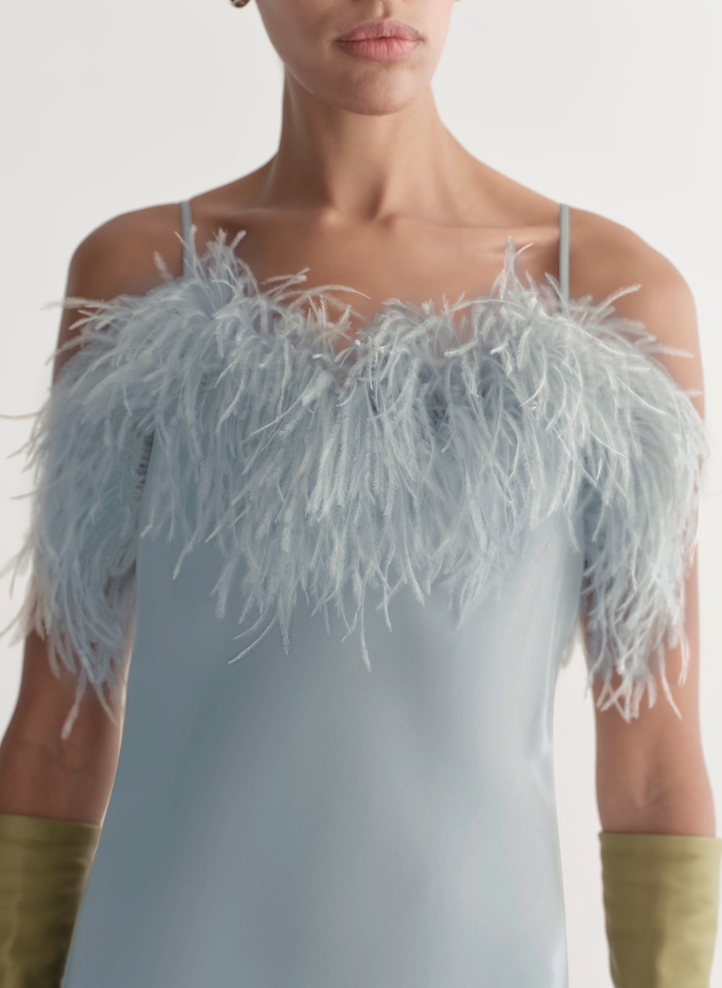 Light blue dress with feathered shoulder details worn by a model against a neutral background