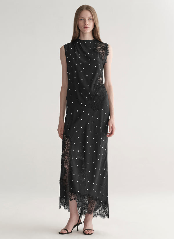 woman wearing black satin and lace polka dot top and matching midi skirt