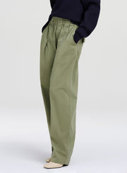 Person wearing olive green pants on a white background