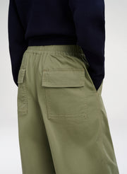 Green pants worn by a person on a white background