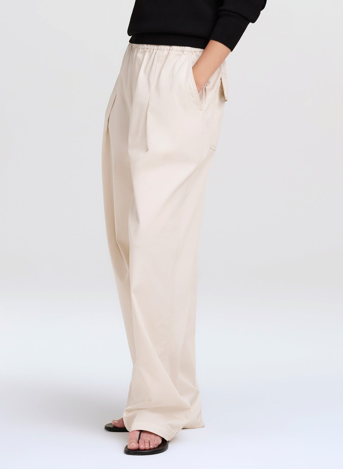 Person wearing beige pants on a white background