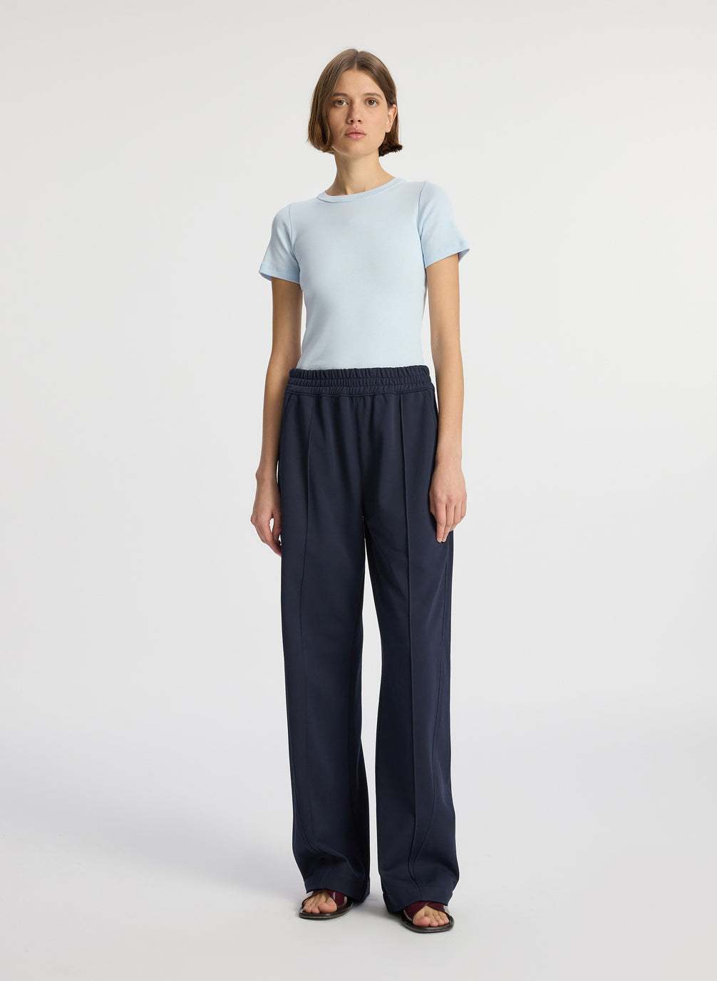 front view of woman wearing light blue tshirt and navy blue pants
