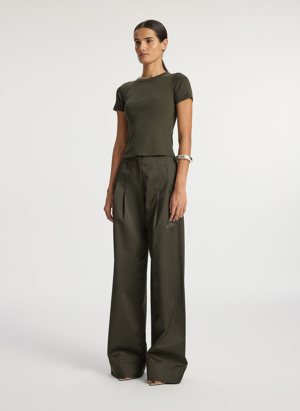 side  view of woman wearing olive green tshirt and olive green wide leg pants