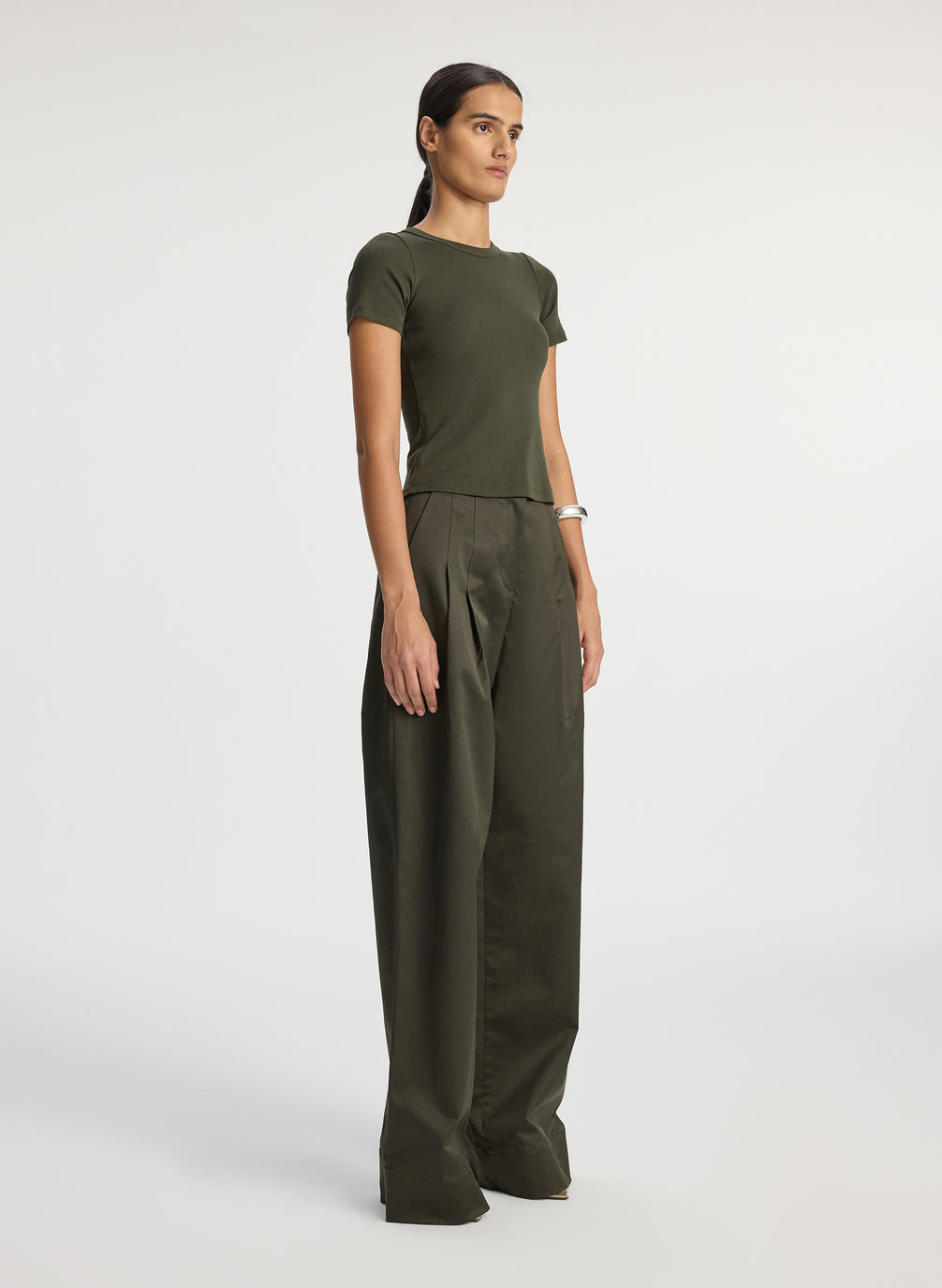 side  view of woman wearing olive green tshirt and olive green wide leg pants