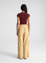 woman wearing burgundy short sleeve fine gauge knit cardigan with tan wide leg pants