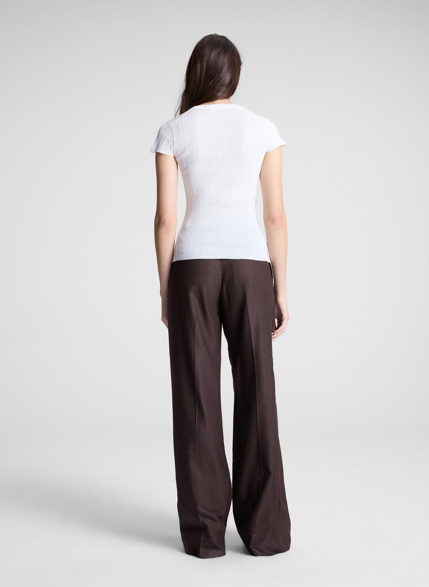 woman wearing white cardigan and brown pants