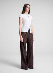 woman wearing white cardigan and brown pants