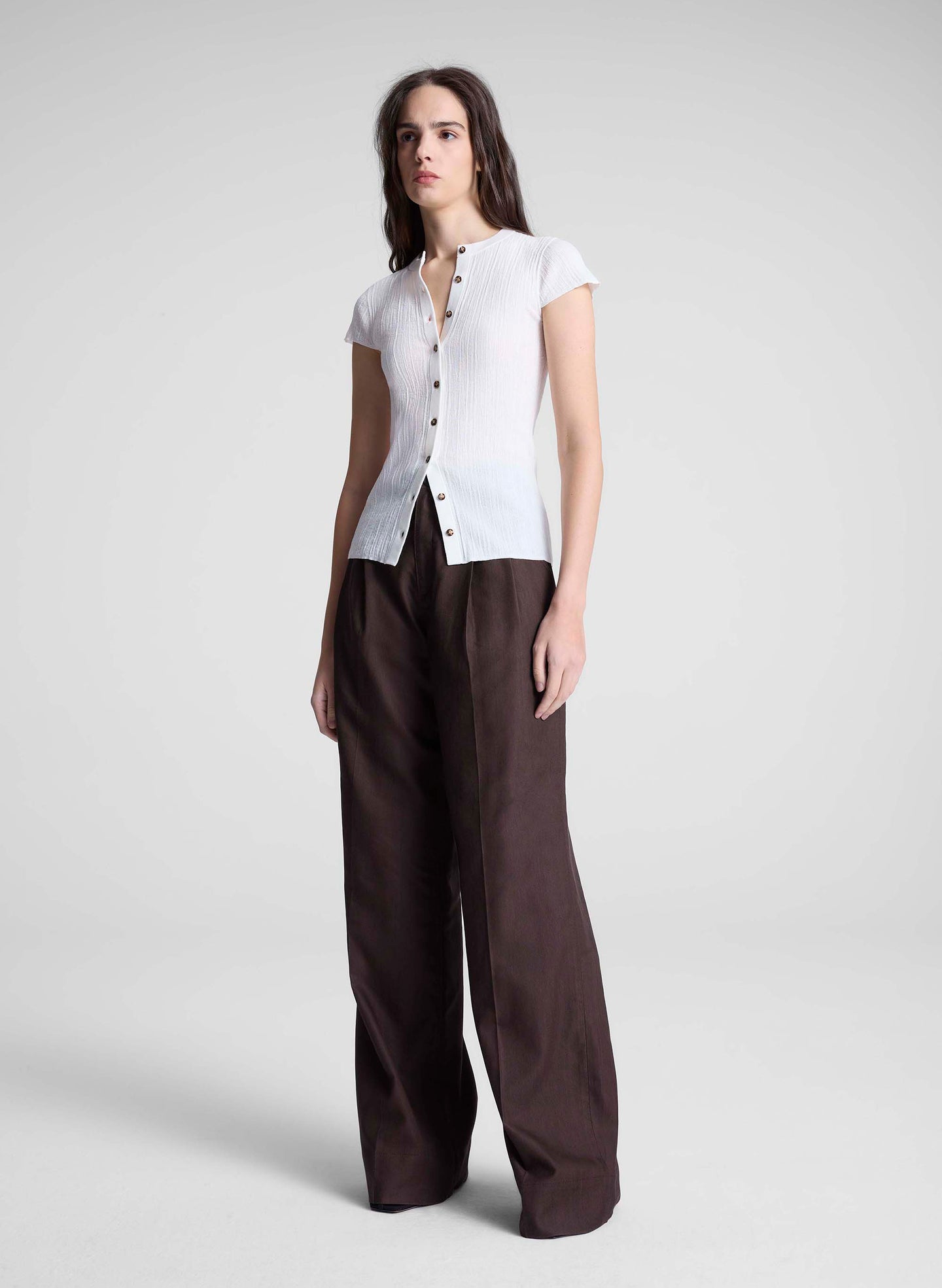 woman wearing white cardigan and brown pants