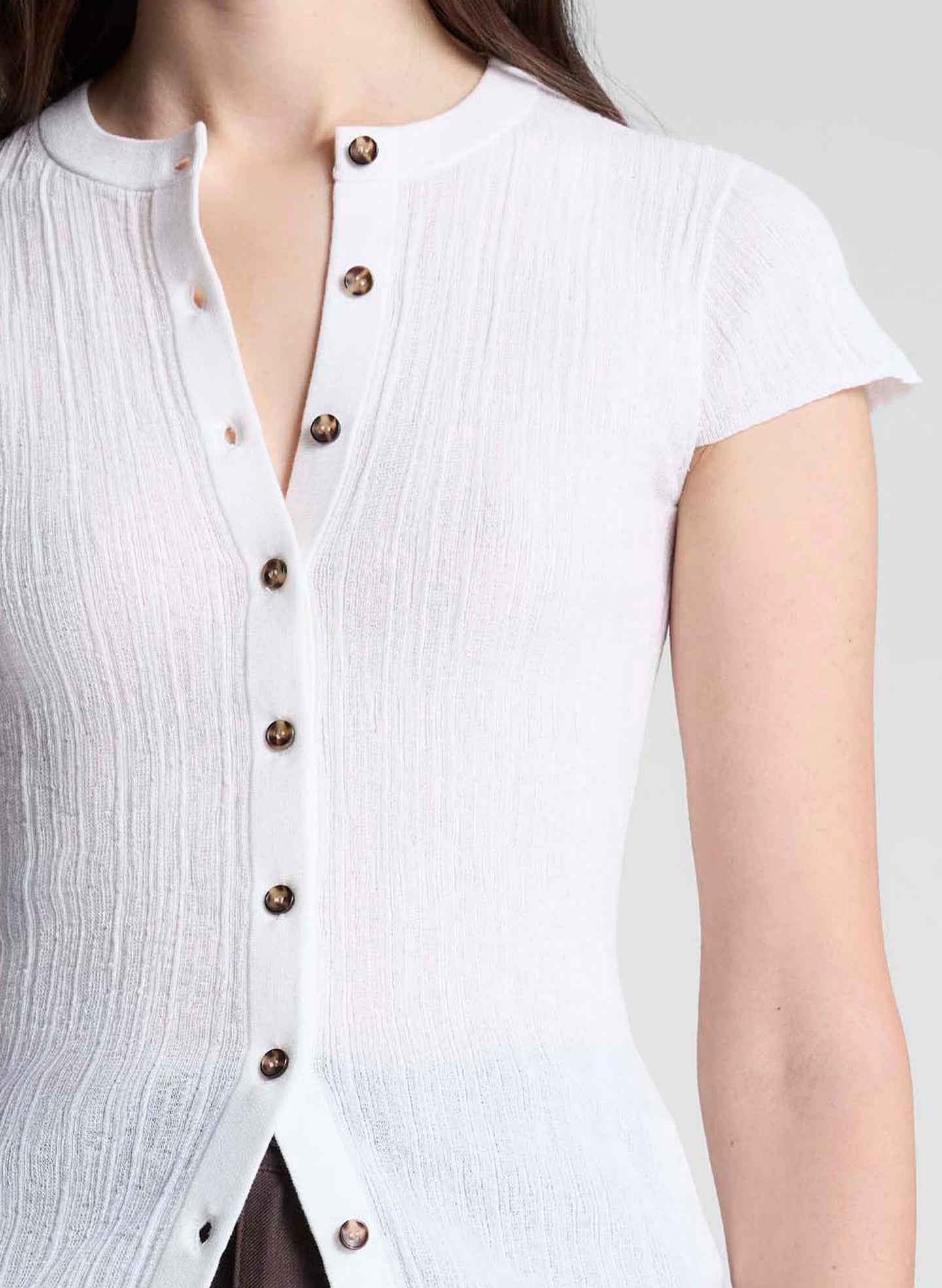 woman wearing white cardigan and brown pants