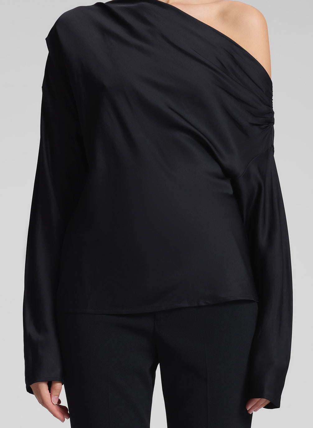 woman wearing black satin one shoulder top and black pants