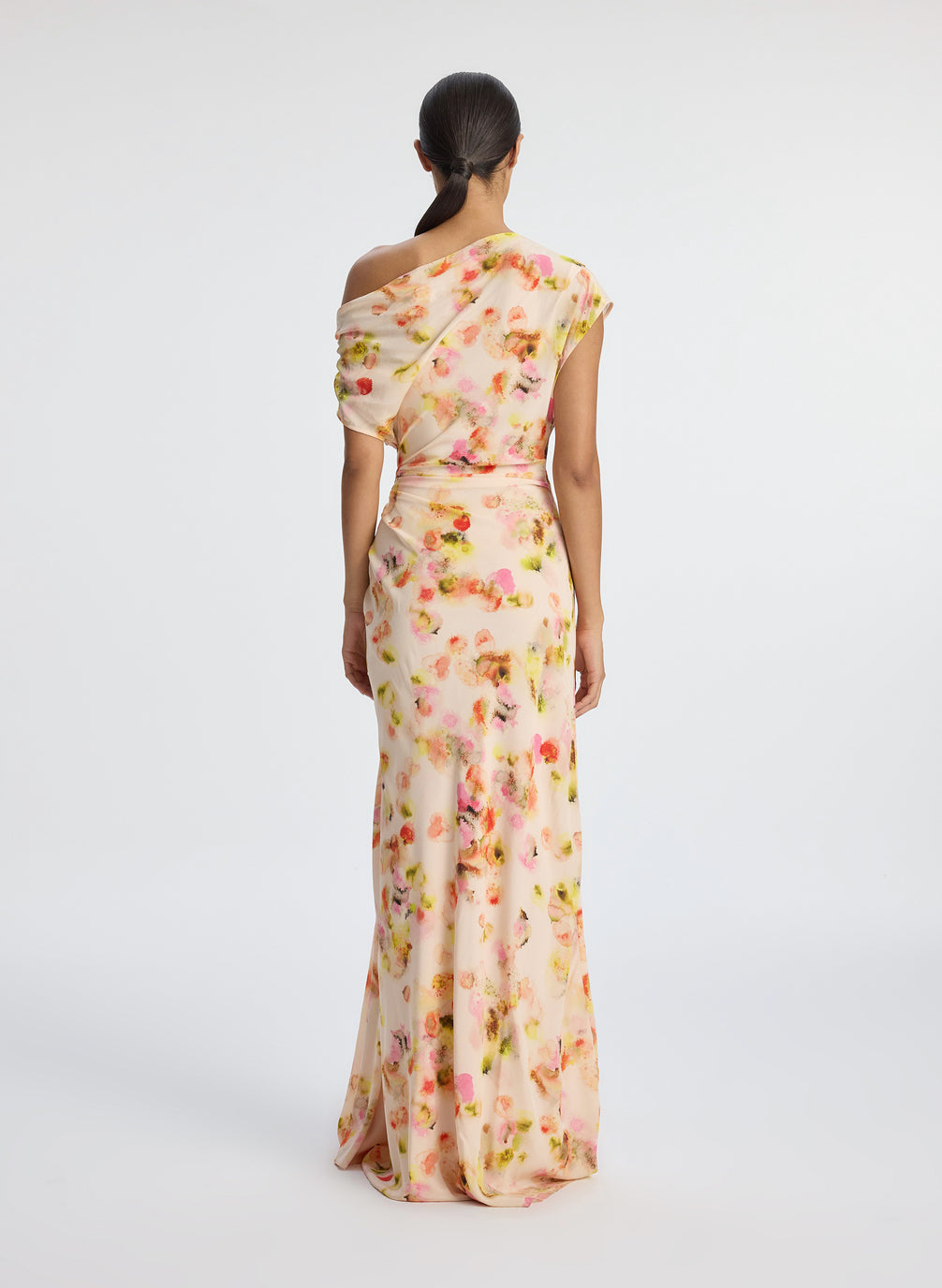 back  view of woman wearing abstract print satin one shoulder maxi dress