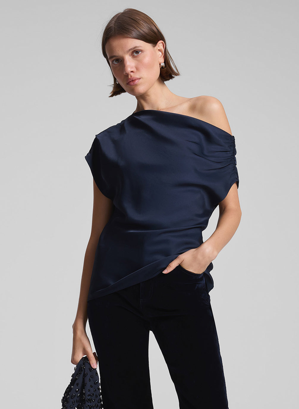 woman wearing navy blue one shoulder top and black pants