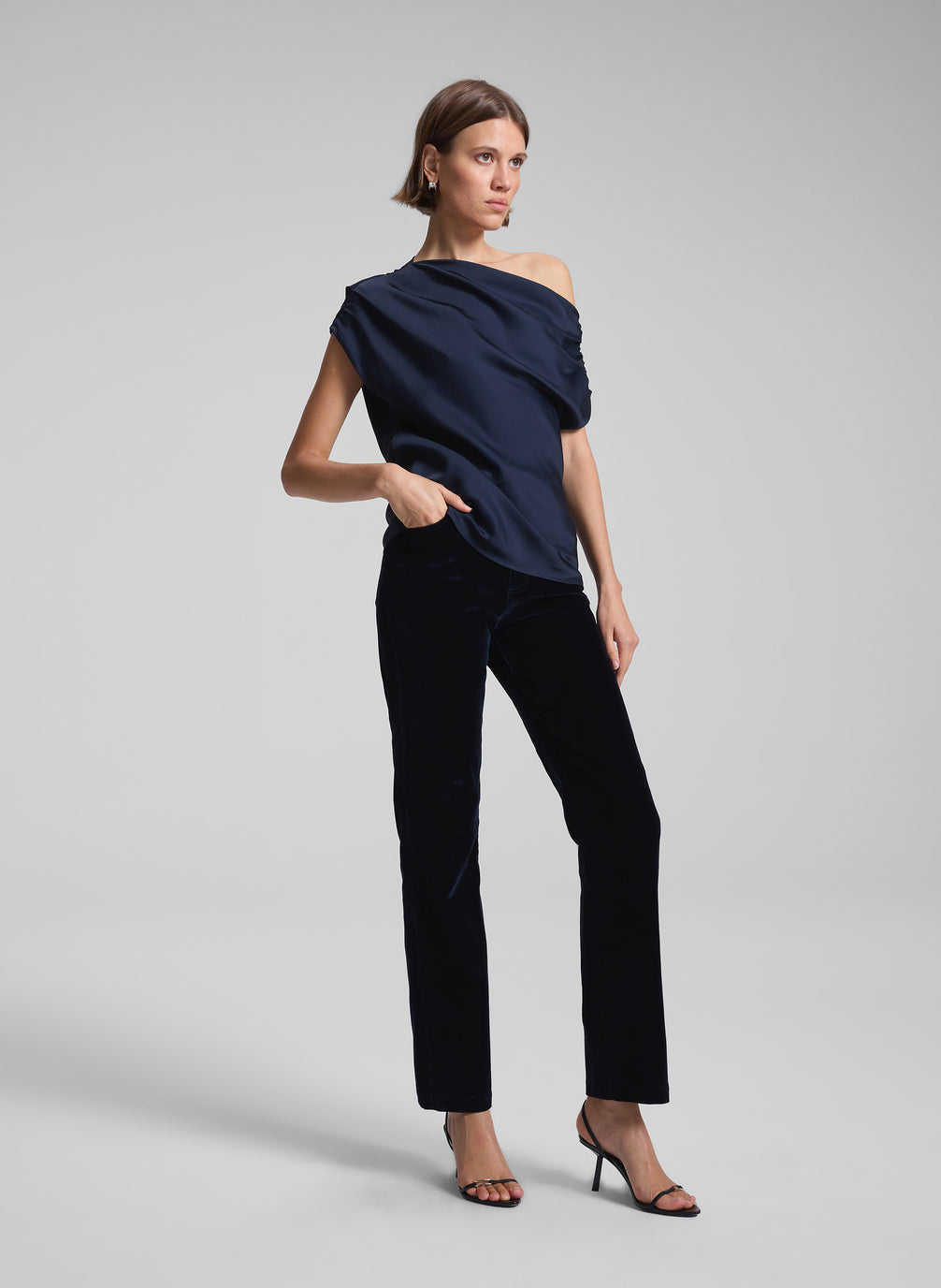 woman wearing navy blue one shoulder top and black pants