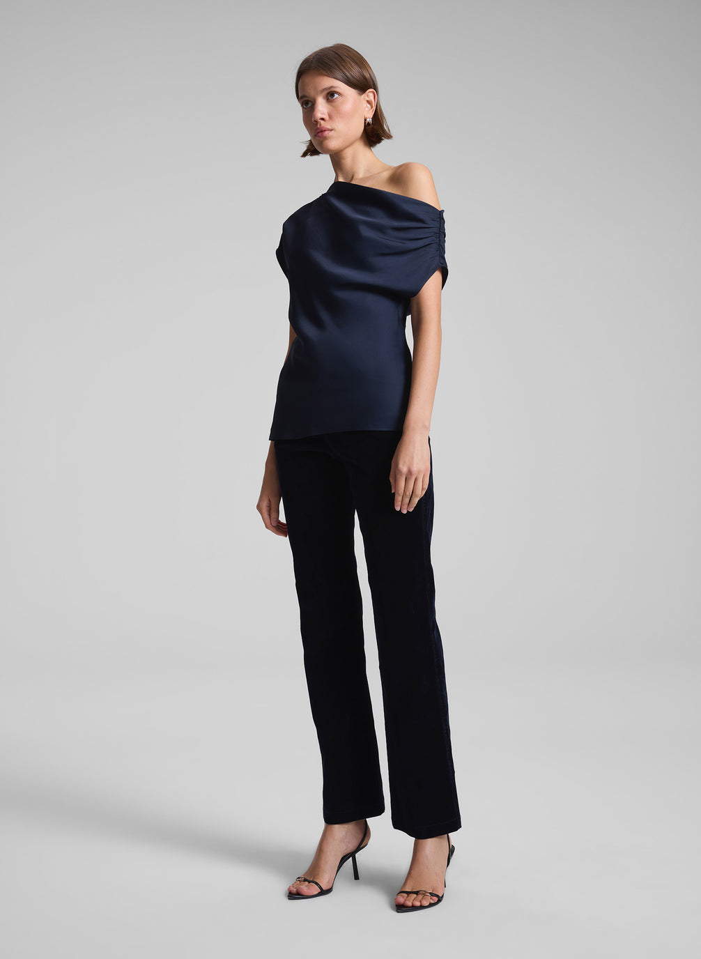 woman wearing navy blue one shoulder top and black pants