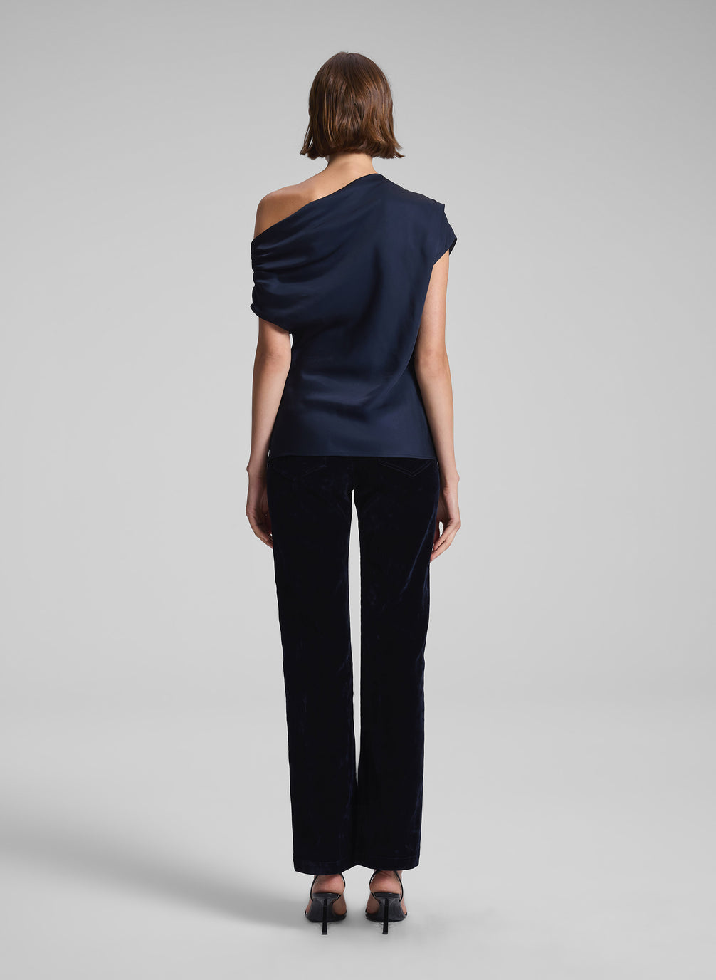 woman wearing navy blue one shoulder top and black pants