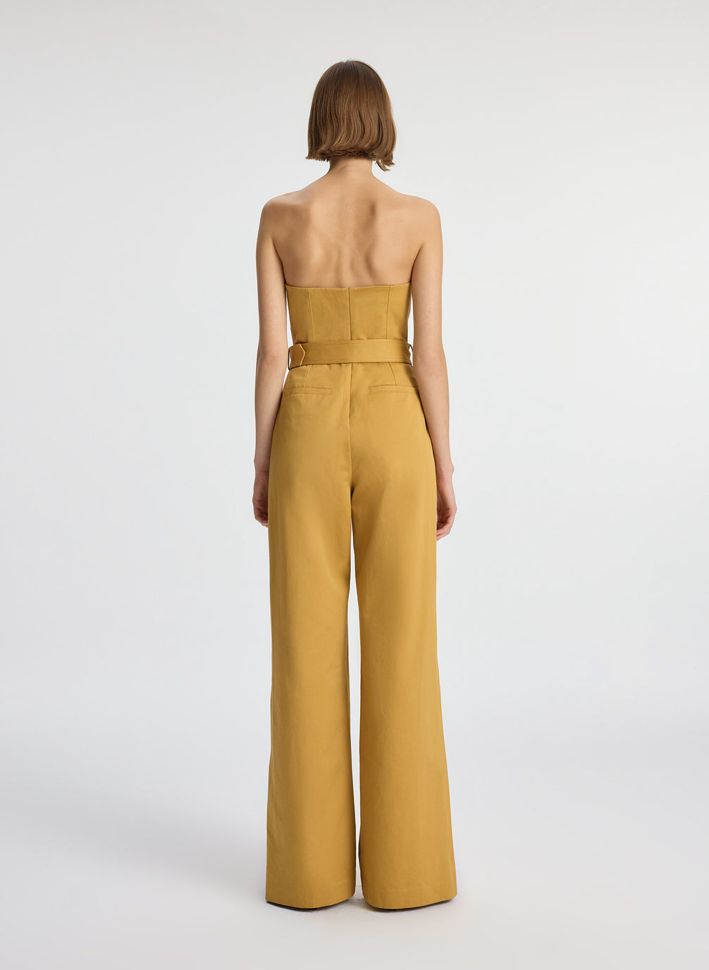 back view of woman wearing tan jumpsuit
